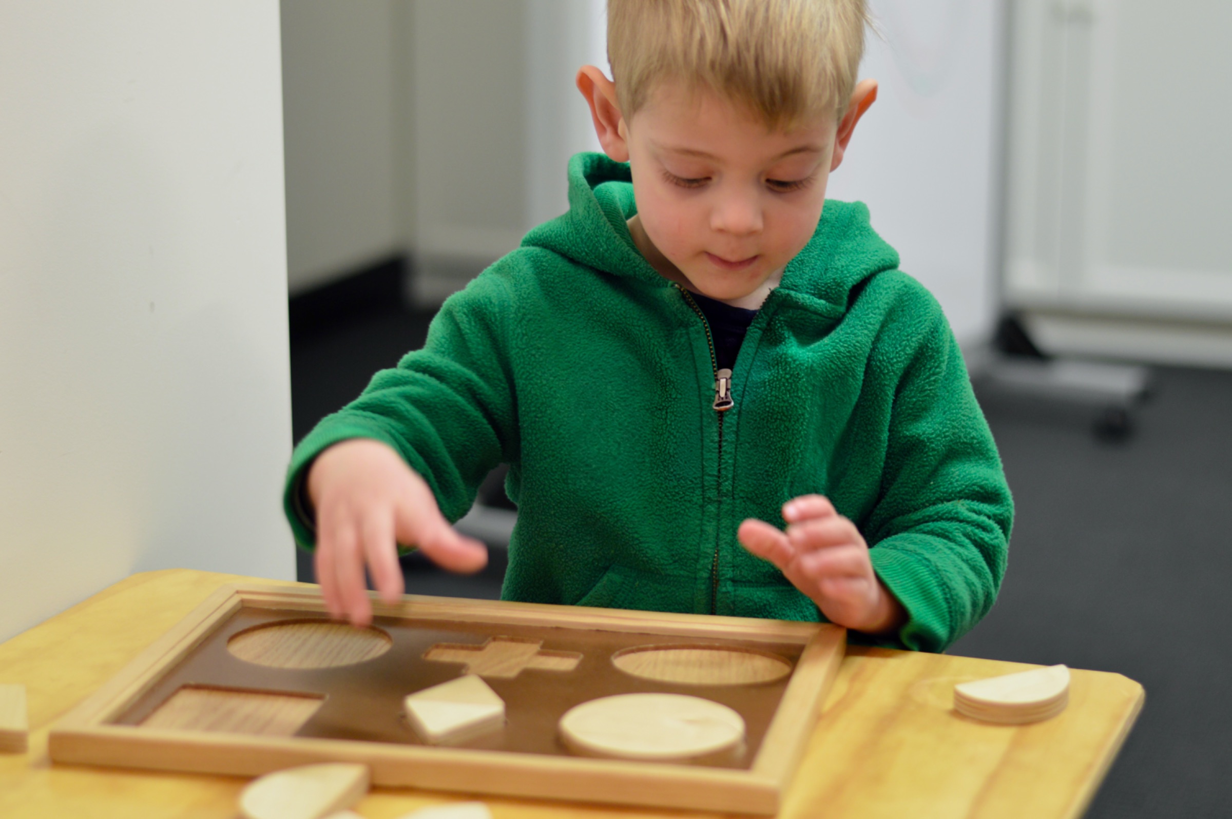 A child completing a shape puzzle during a vision assessment